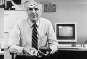 Doug Engelbart hält in seiner linken Hand seine erste Maus von 1963 und in seiner rechten Hand eine modernere maus (ca. 1984)