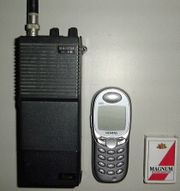Größenvergleich: Icom IC-2E (links) mit modernem Handy und Streichholzschachtel