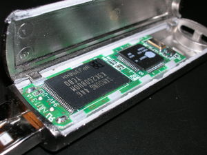 geöffneter USB-Stick – der linke Chip ist der eigentliche Flashspeicher, der rechte ein Mikrocontroller.